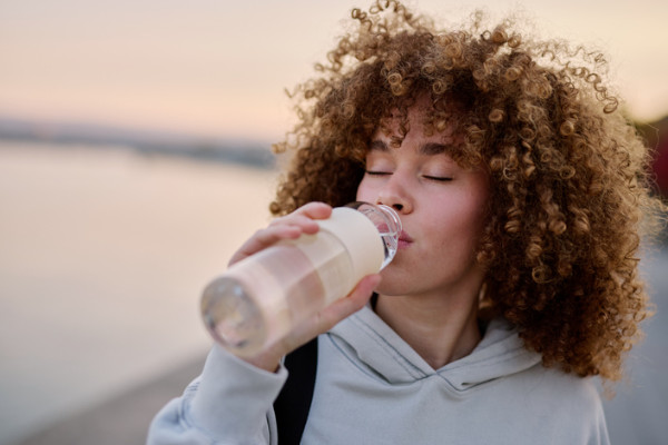 A woman drinking from a water bottle