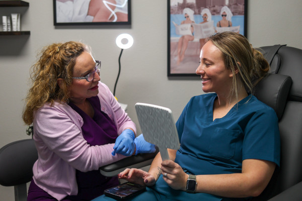 Joplin ENT's Ginnie Grimm showing a patient the results of their treatment