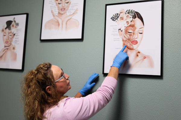 Joplin ENT's Ginnie Grimm using a wall-mounted diagram to explain treatment to a patient